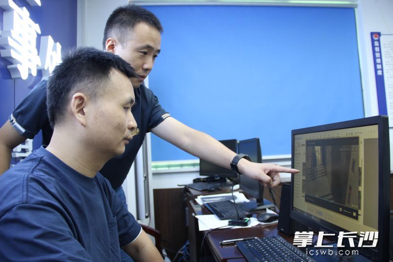 彭文杰（右）和同事在调看电动车进电梯预警系统画面。长沙晚报全媒体记者 聂映荣 摄